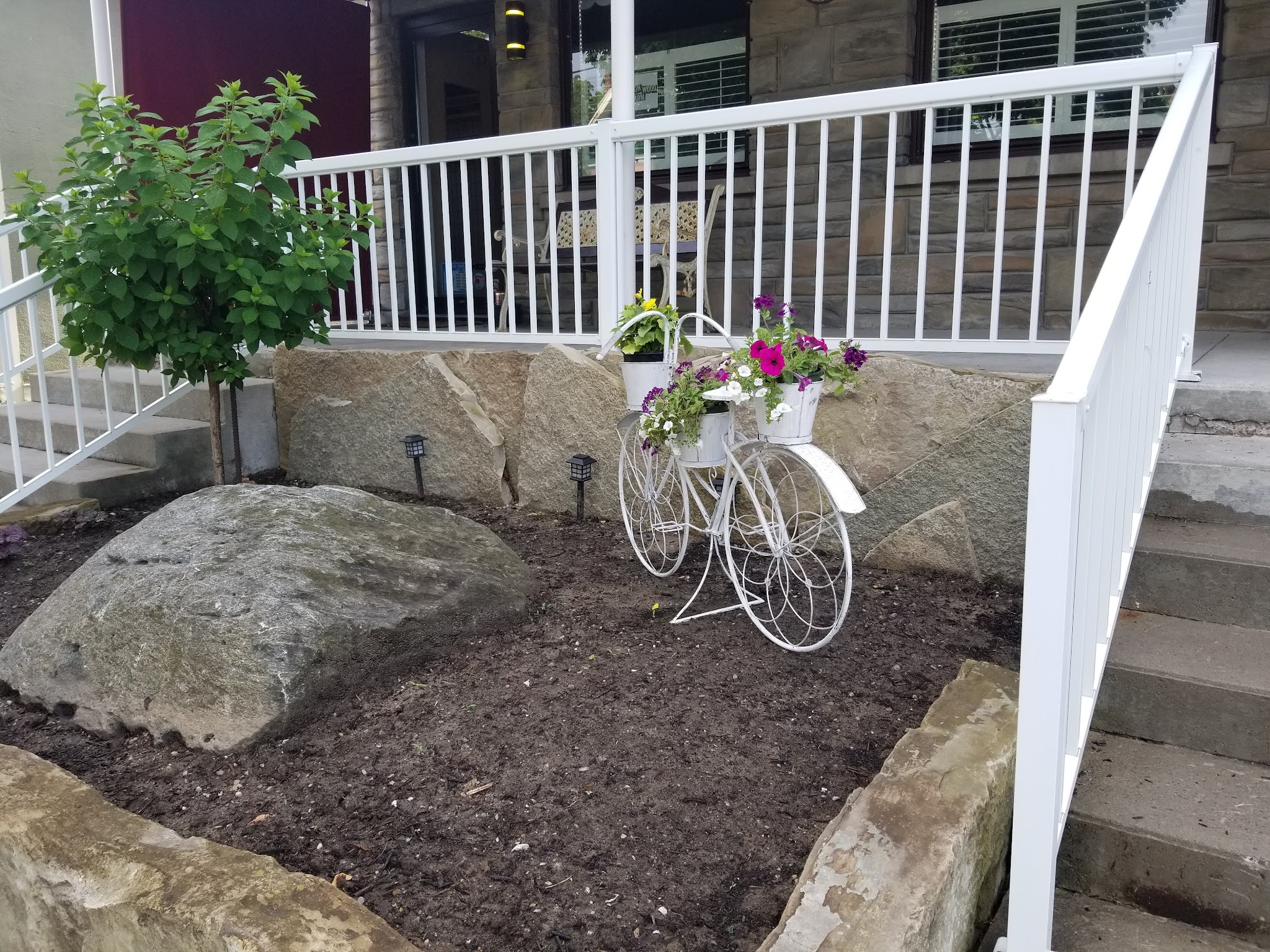 White decorative bicycle planter on the front porch